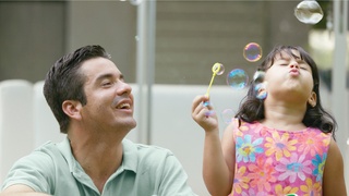 Father with daughter blowing bubbles